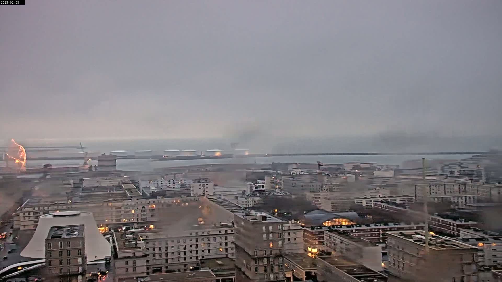 A high-angle view shows a city harbor under an overcast sky with a lightning strike visible near the docks.
