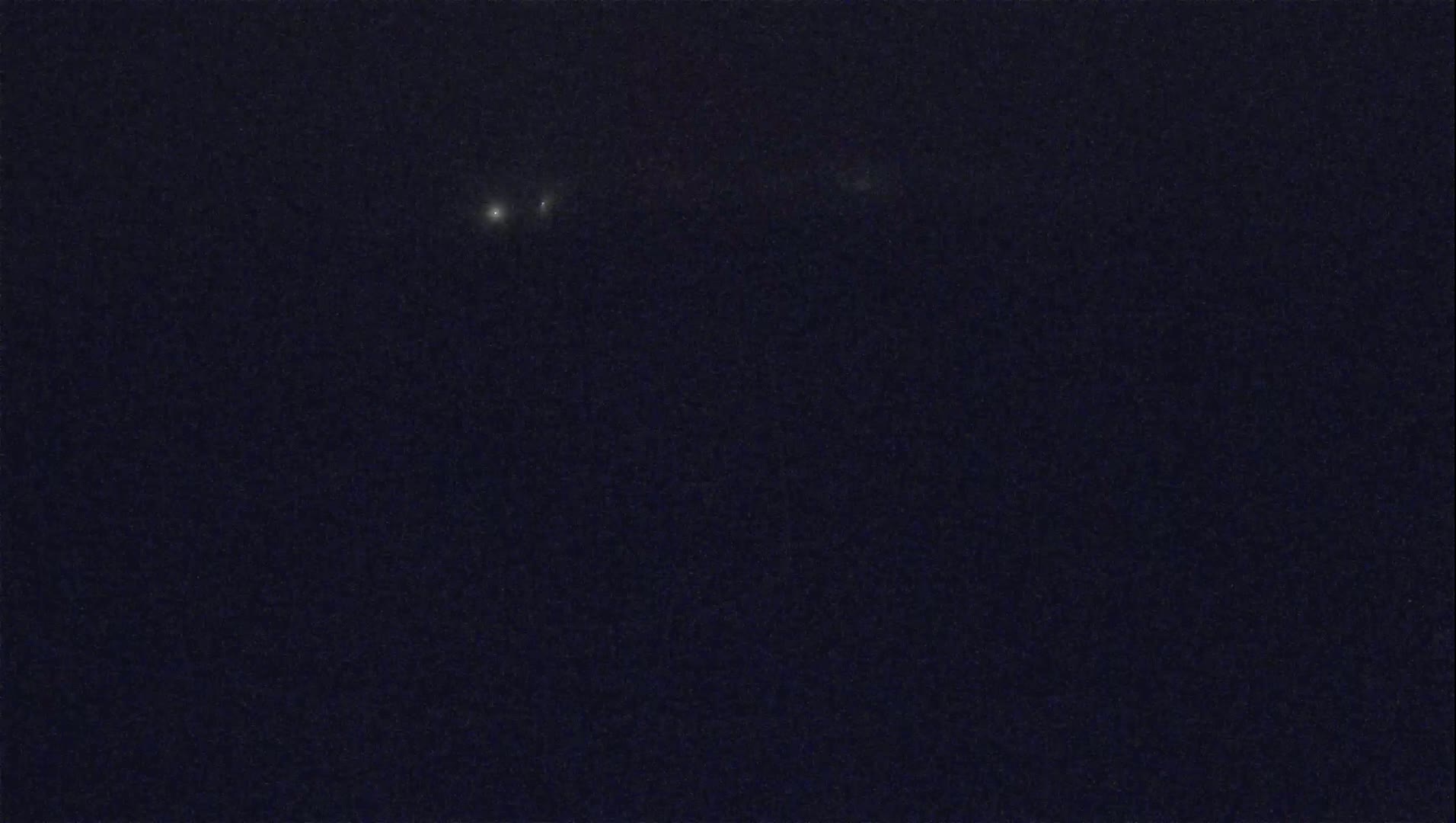 A dark, night sky shows three small, bright lights in a slightly diagonal line.