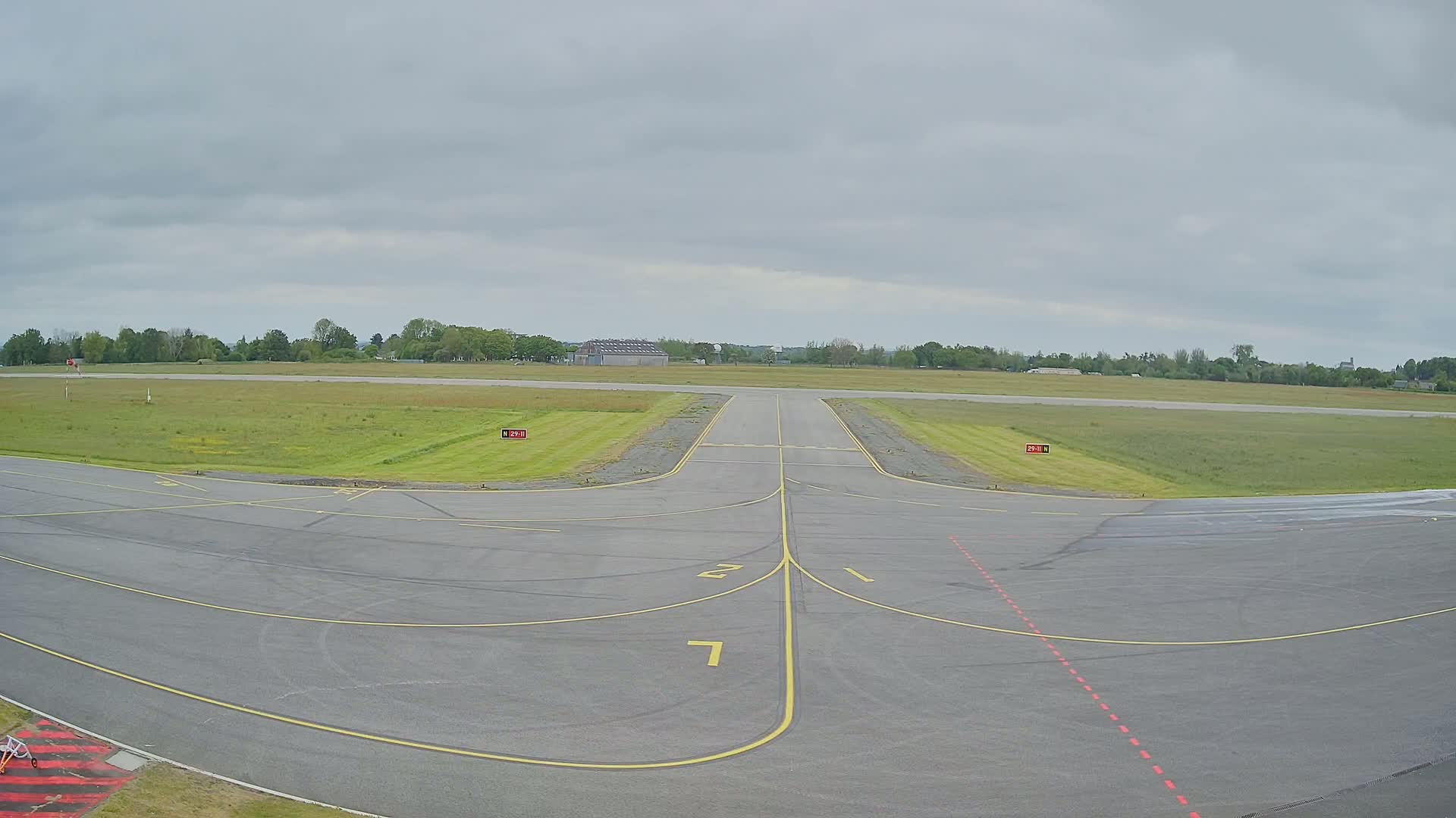A runway at a small airport on an overcast day.