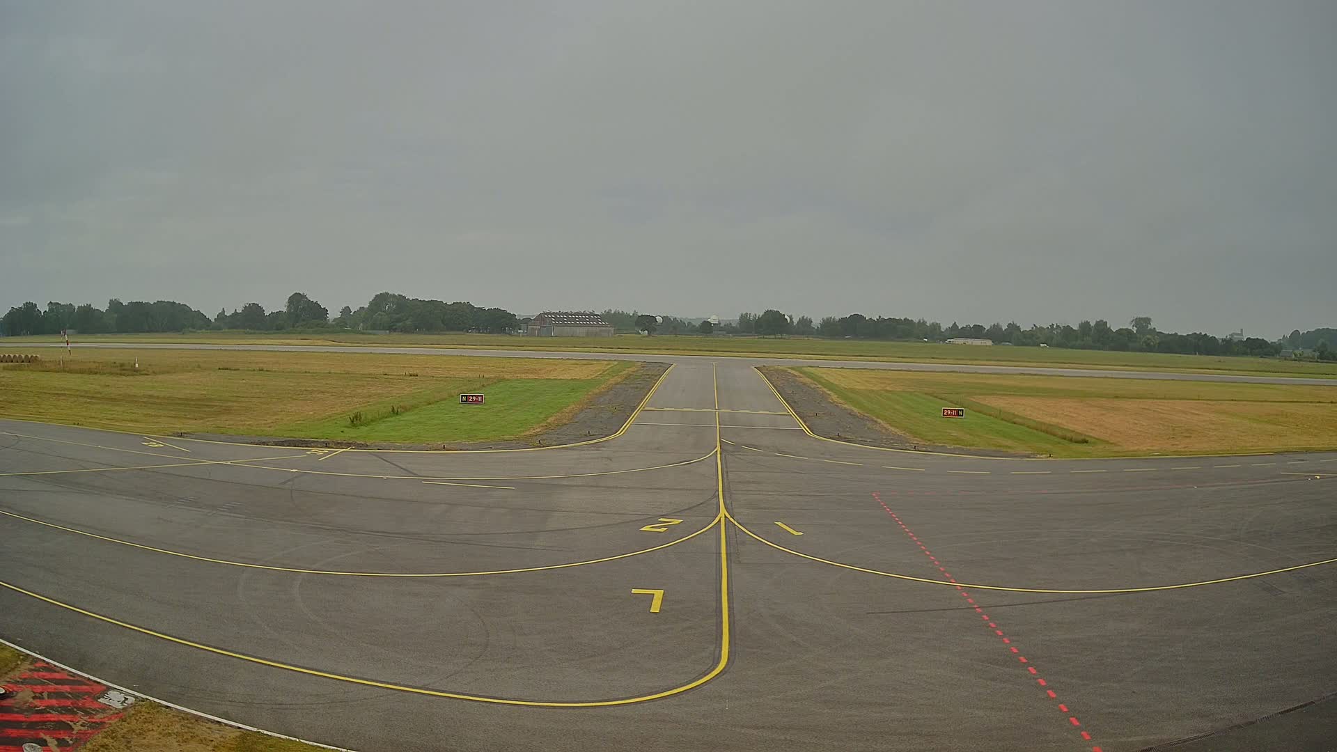 A runway at an airport on an overcast day.