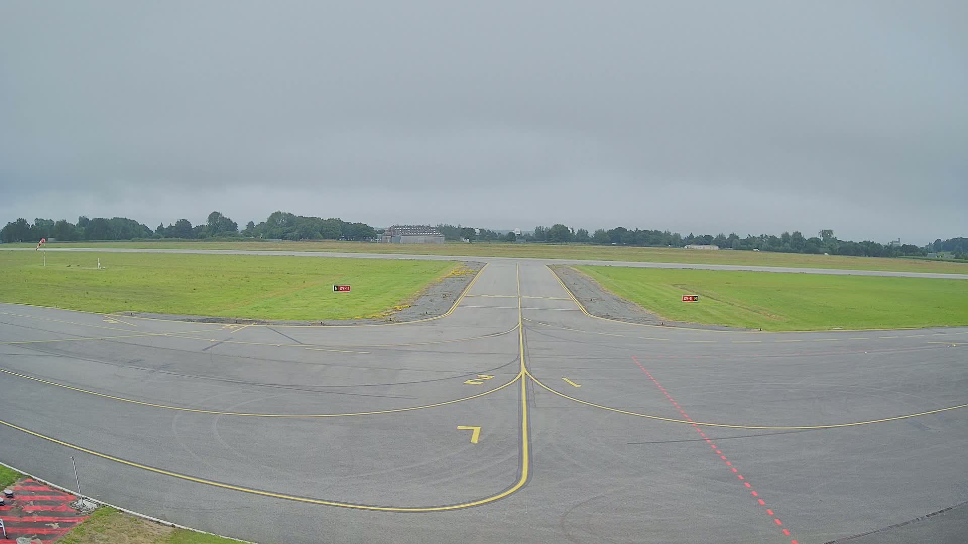 A runway at a small airport on an overcast day.