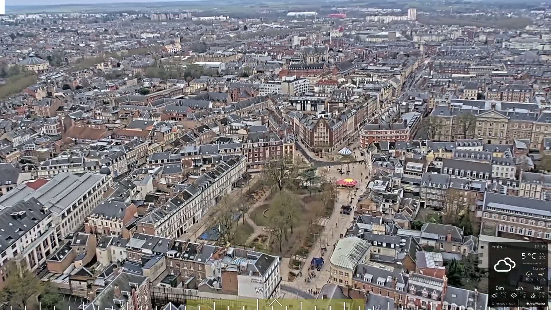 A high-angle, wide view of a densely packed European city on a cloudy day with a temperature of 5°C.