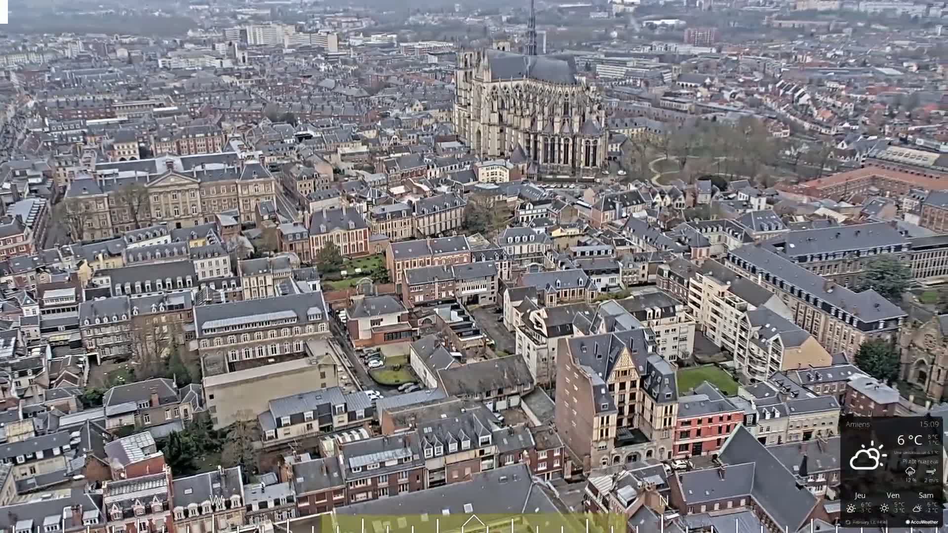 An aerial view of a European city on an overcast day shows a large cathedral and many closely spaced buildings.