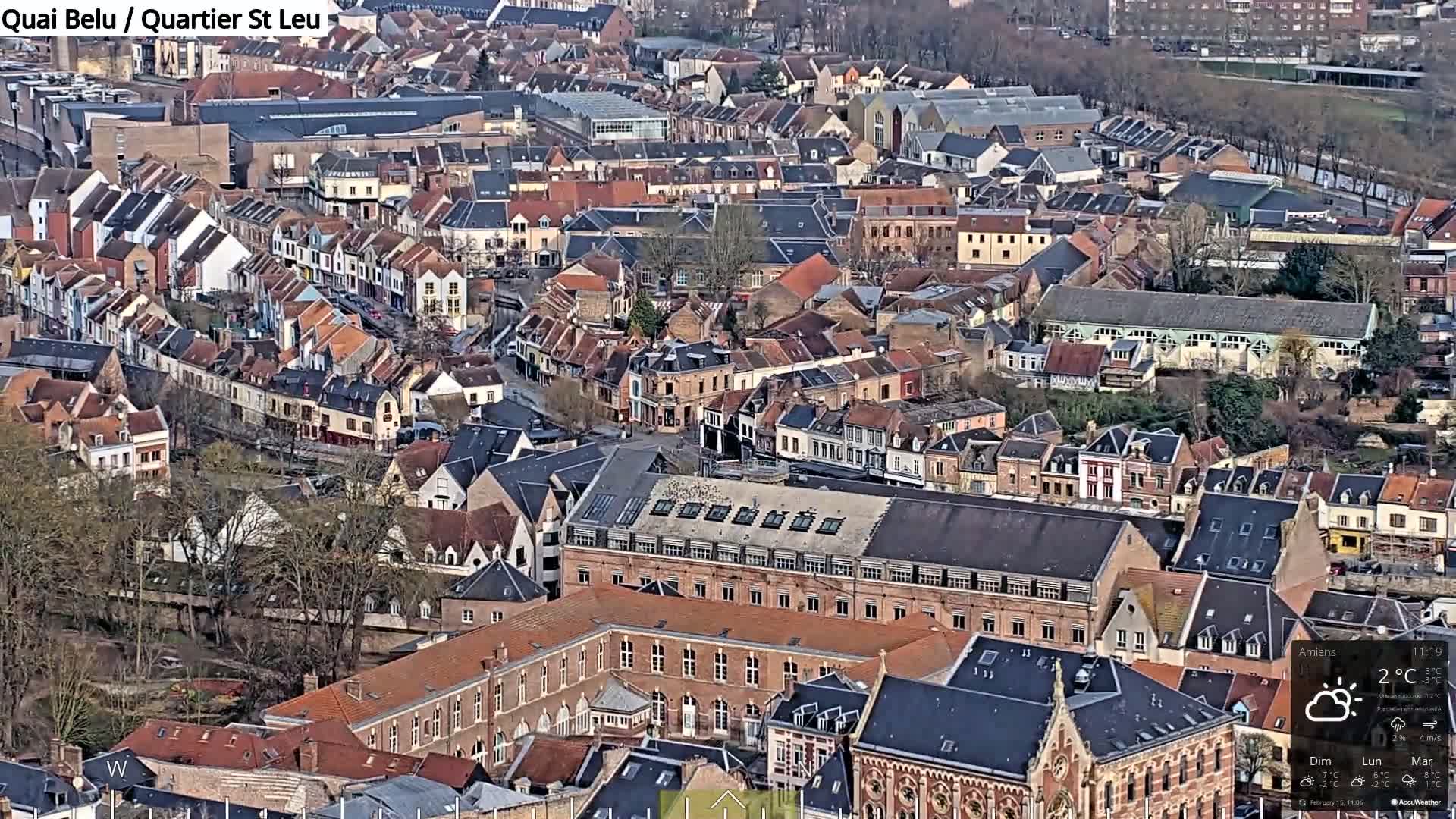 An aerial view of a densely packed European city on a partly cloudy day with a temperature of 2°C.