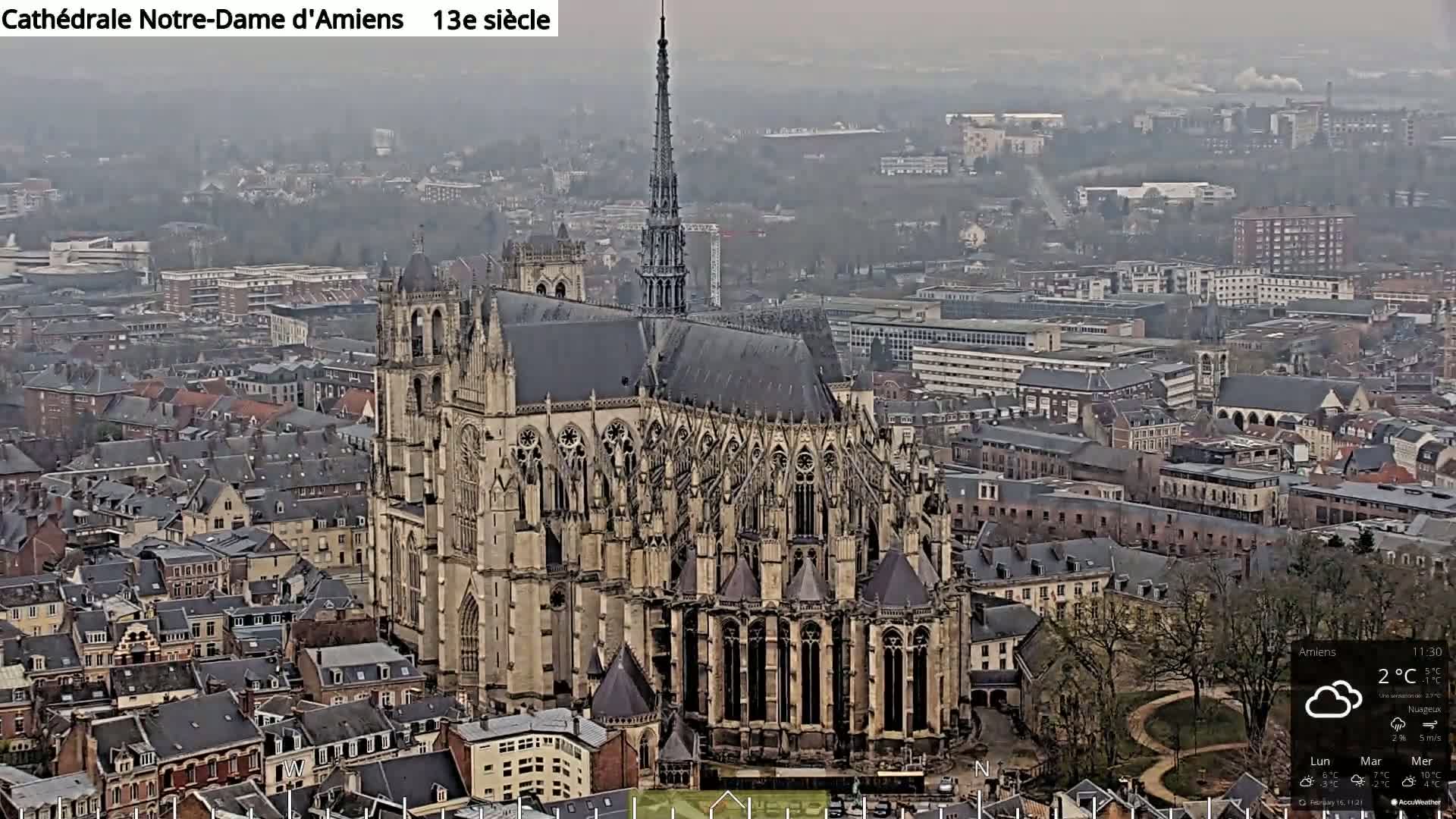 A large Gothic cathedral sits in a city on an overcast day.