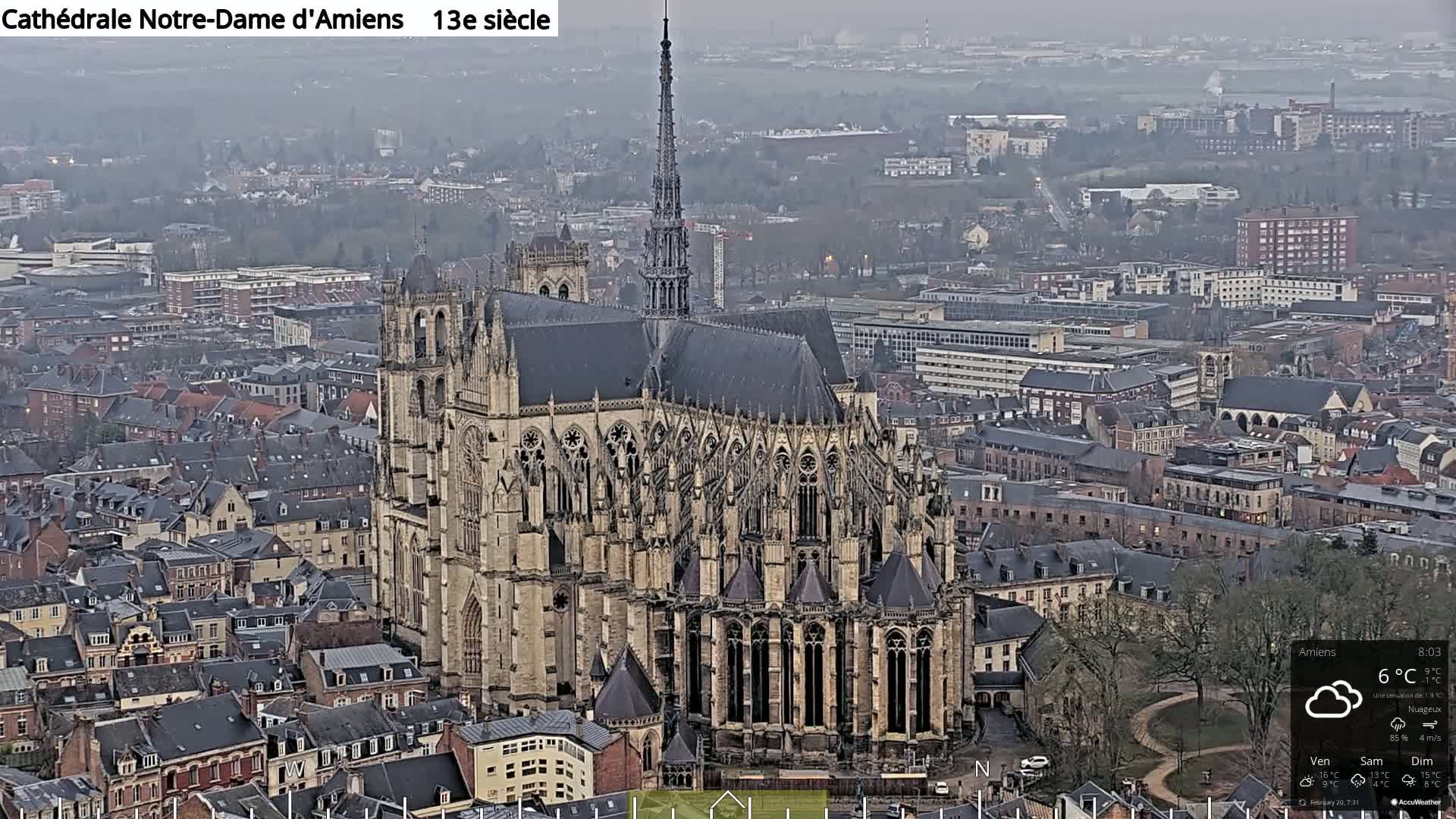 A large Gothic cathedral stands in a city on an overcast day.