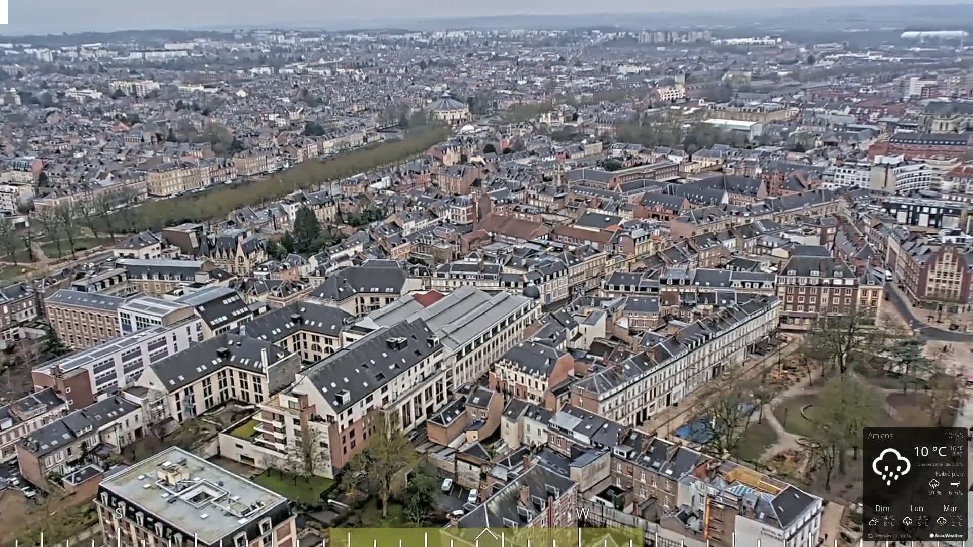 An aerial view of a densely packed city on an overcast day with light rain.