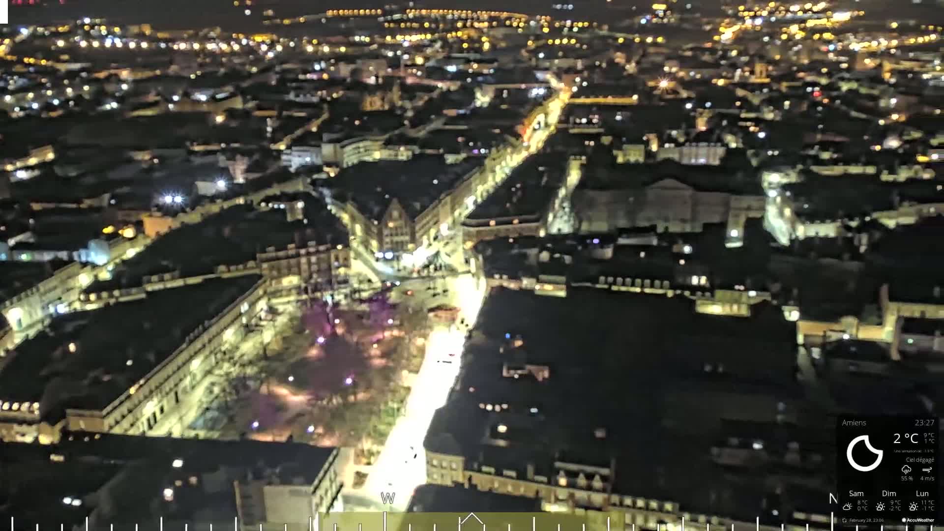 A nighttime aerial view of a brightly lit city with a clear sky.