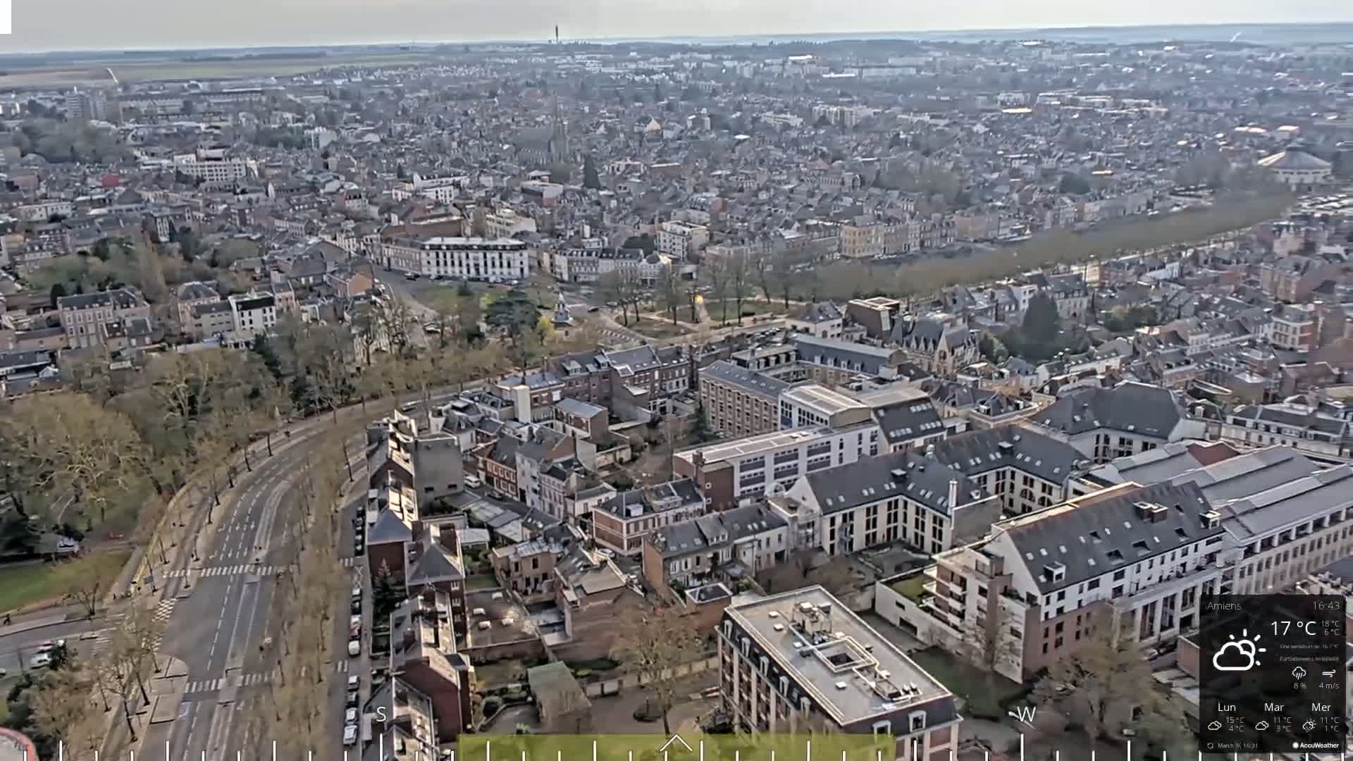 A high-angle, long shot of a densely populated city on a partly sunny day.