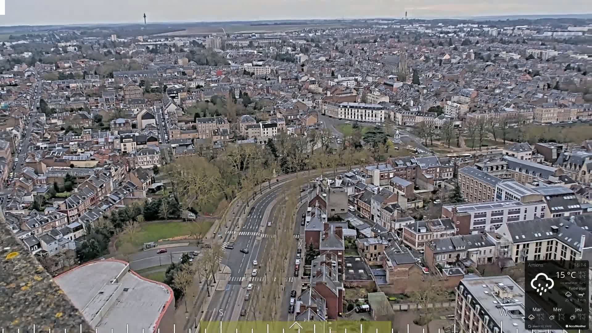 A high-angle, long shot of a city on an overcast day with light rain.