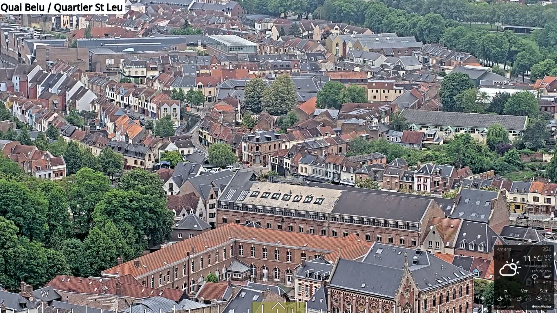 An aerial view of a densely packed European city on a partly cloudy day.