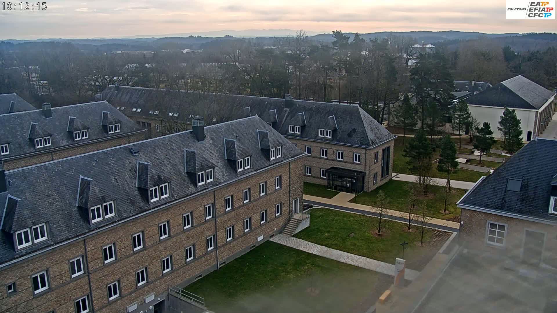 An aerial view of a campus with several stone buildings under an overcast sky.