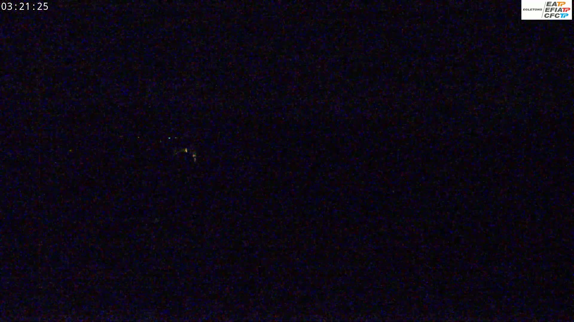 A dark, nighttime scene shows a few faint, distant lights.