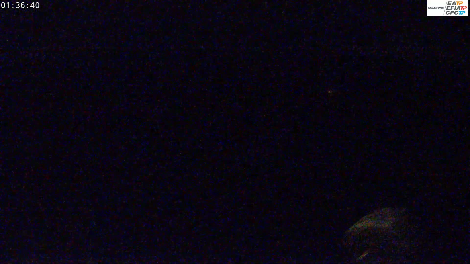 A dark, nighttime scene shows a blurry, indistinct object in the lower right corner.