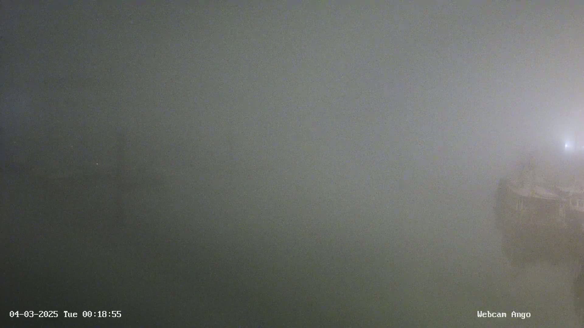 A foggy body of water is visible, with a partially obscured structure on the right.