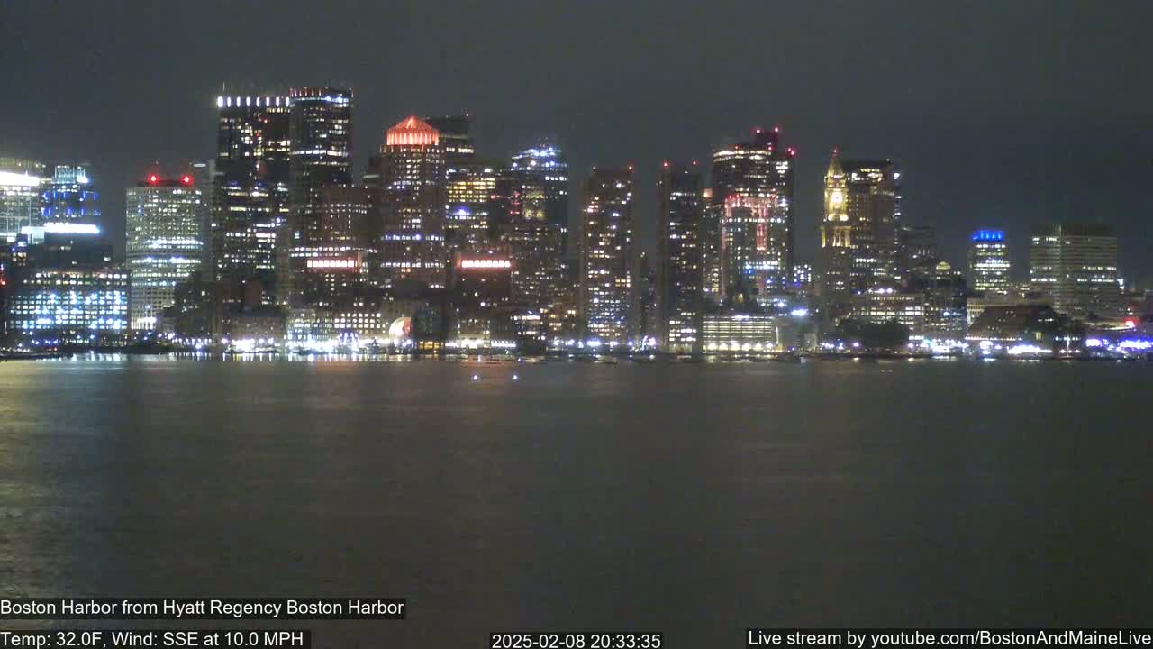 A nighttime view of a city skyline across a dark body of water, under a dark sky with a SSE wind at 10 mph and a temperature of 32°F.