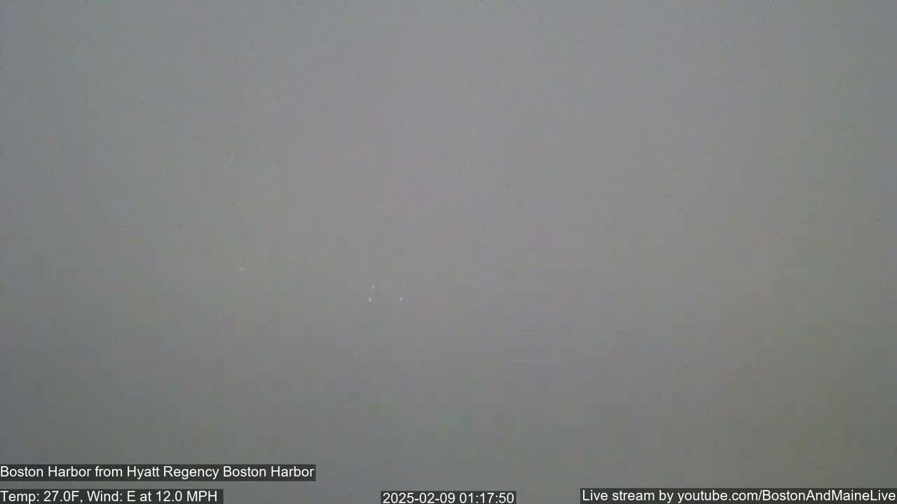 A hazy, gray view of Boston Harbor with an east wind at 12 mph and a temperature of 27 degrees Fahrenheit.