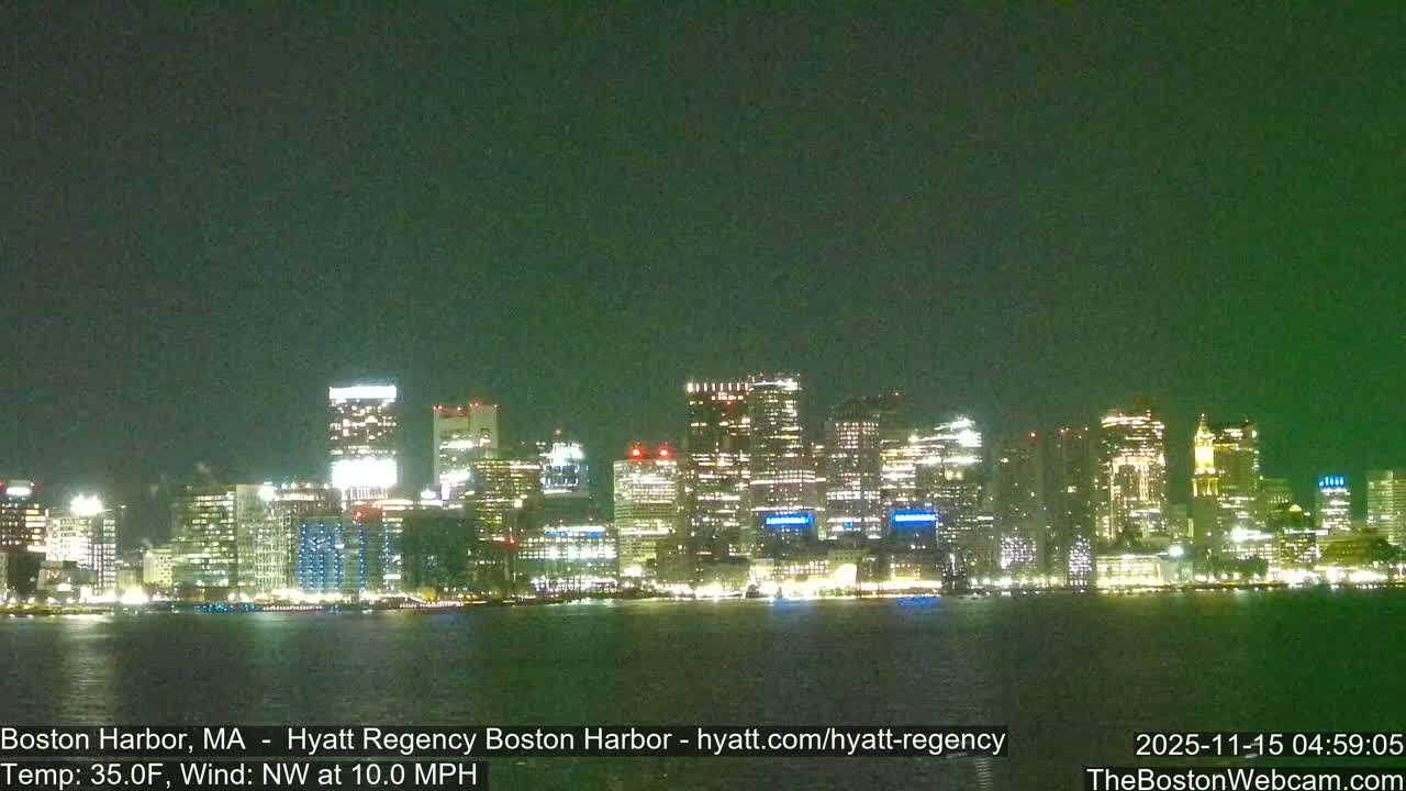 A nighttime view reveals a brightly lit city skyline stretching across a body of water under a dark, greenish sky, with a temperature of 35.0F and wind from the NW at 10.0 MPH.