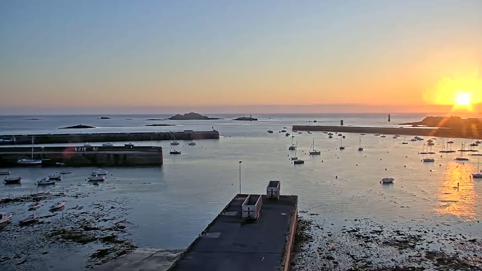 A harbor filled with boats at sunset, under a clear sky.