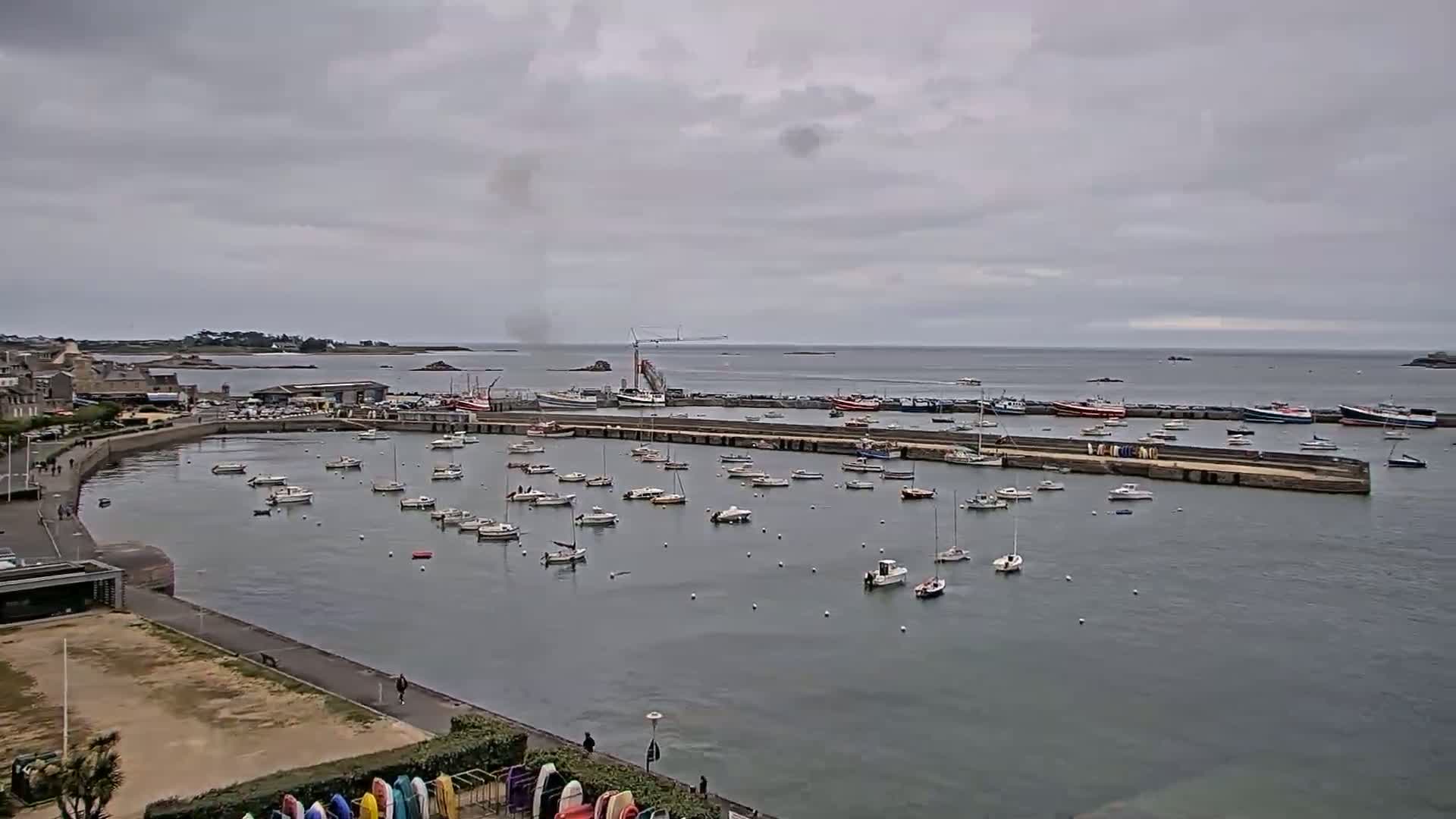A harbor filled with numerous small boats under a cloudy sky.