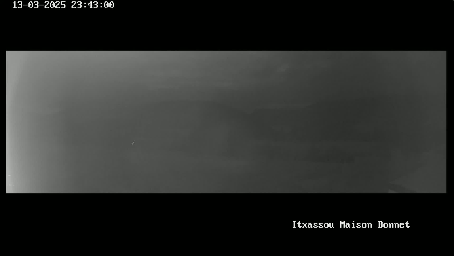 A dark, blurry image shows a mostly featureless, hazy landscape at night.
