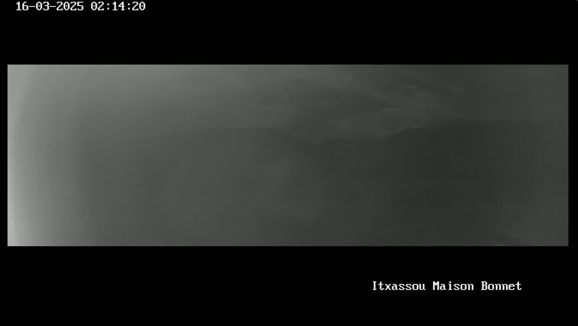 A hazy, overcast sky obscures a distant mountain range.