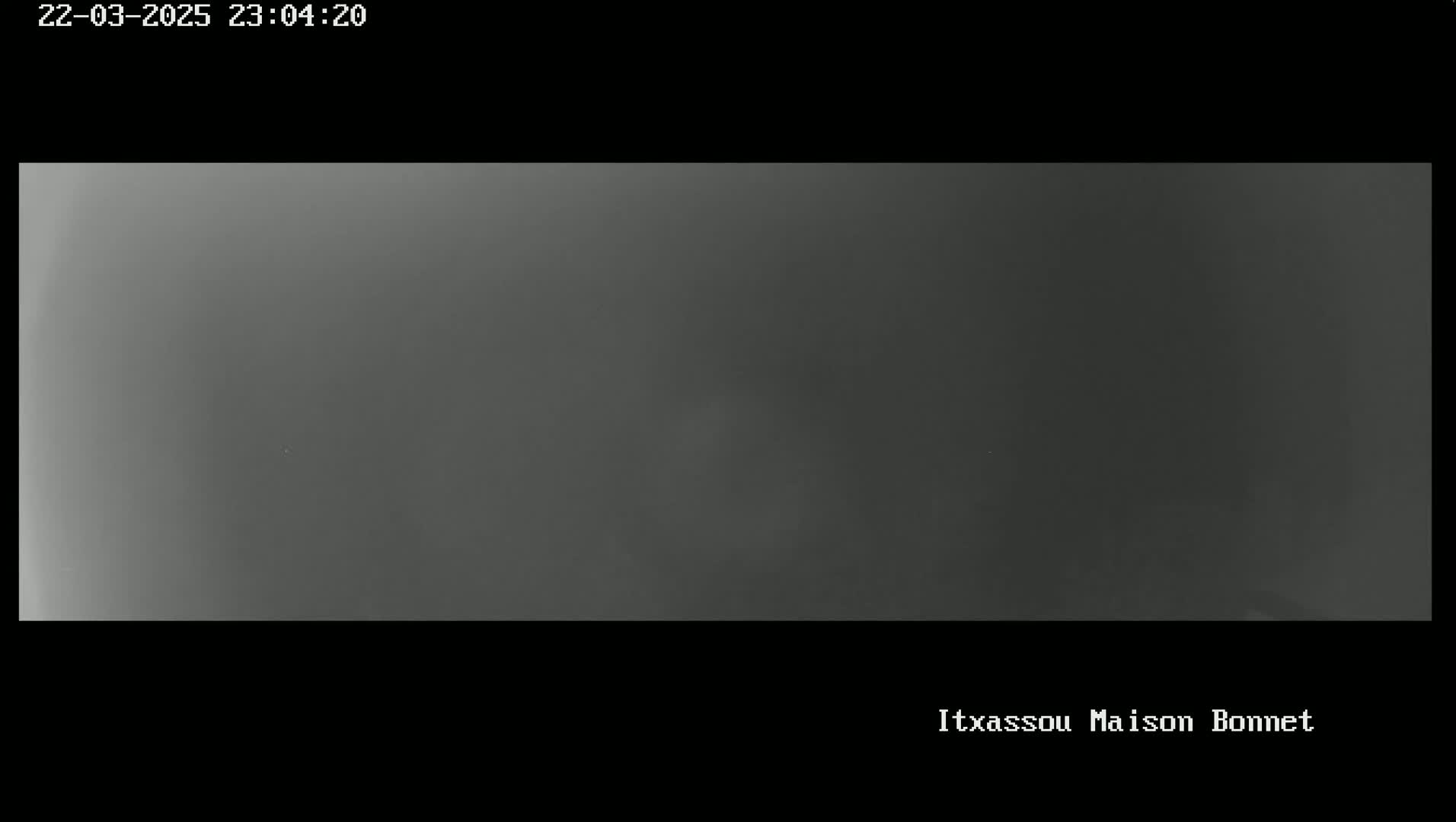 A grayscale image shows a uniformly dark gray scene, possibly taken at night or in foggy conditions.