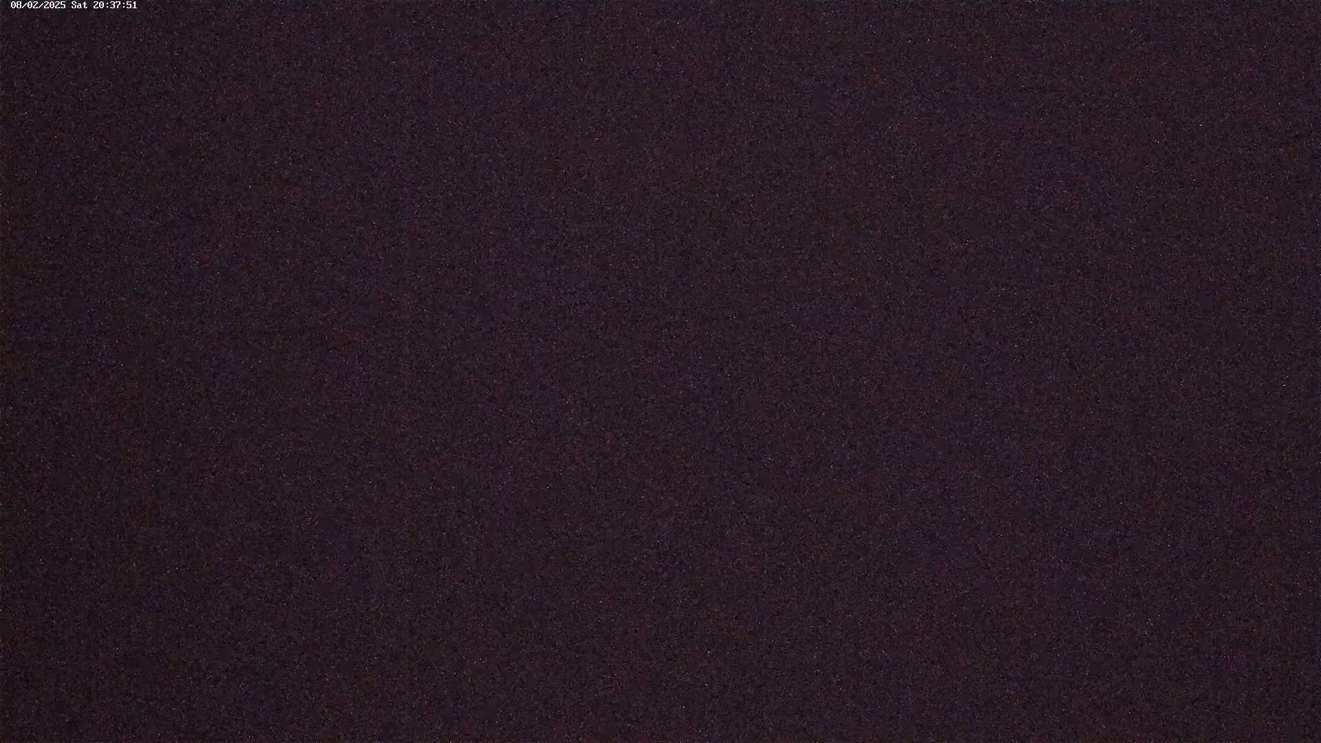 A dark, grainy image, possibly of a night sky.