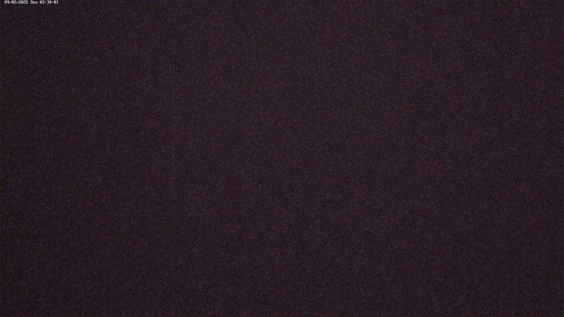A dark, grainy image shows a night sky.