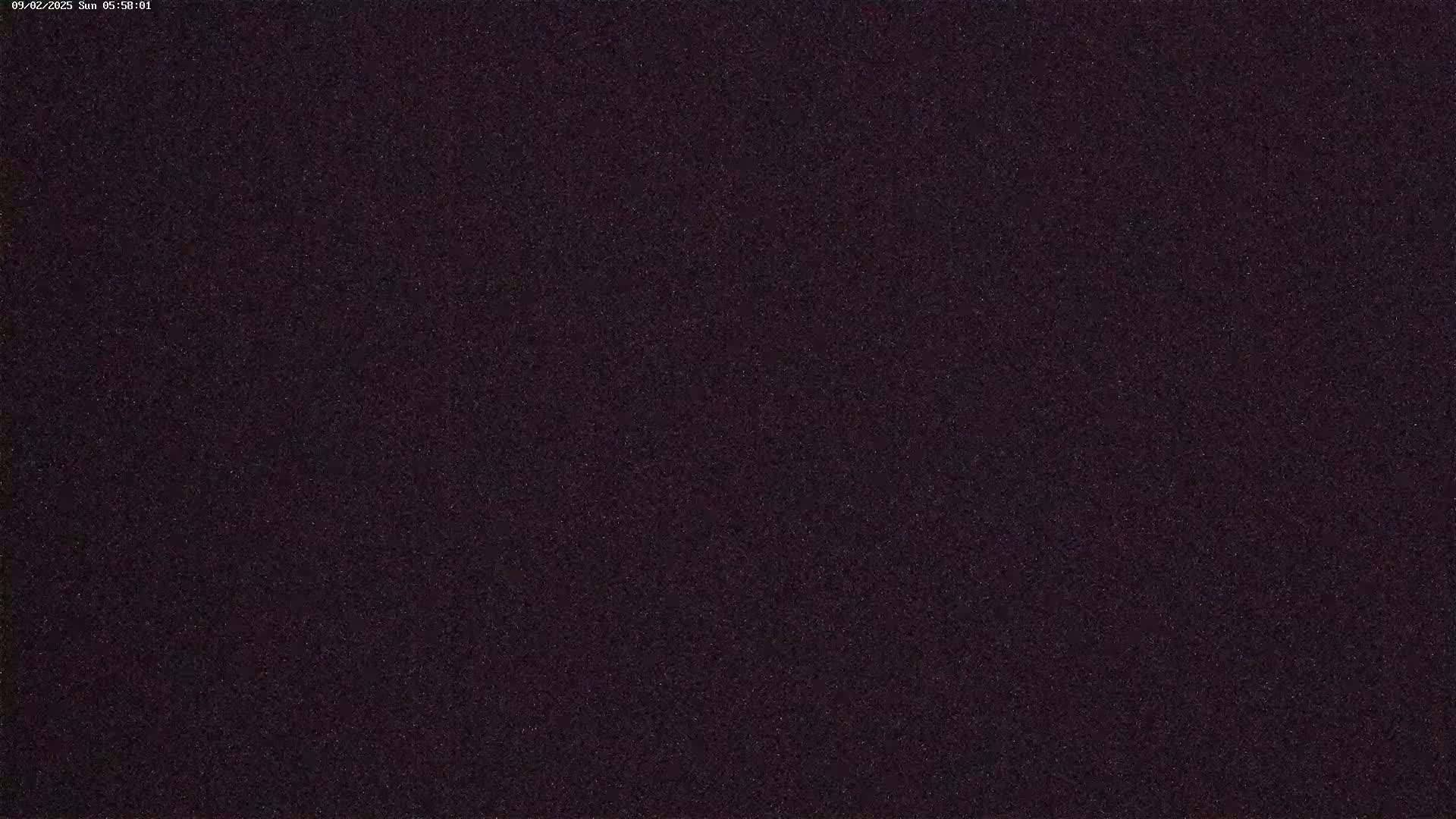 A dark, grainy image shows a night sky with many stars visible.