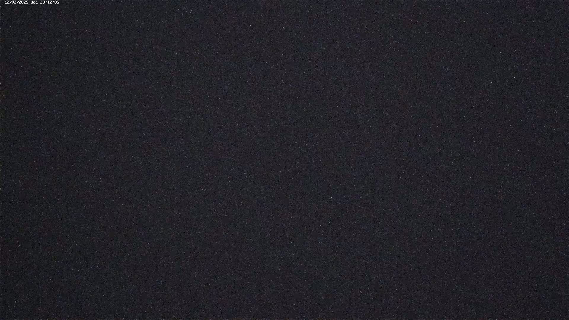 The image shows a dark, grainy texture that appears to be a night-time view of a mostly clear sky.