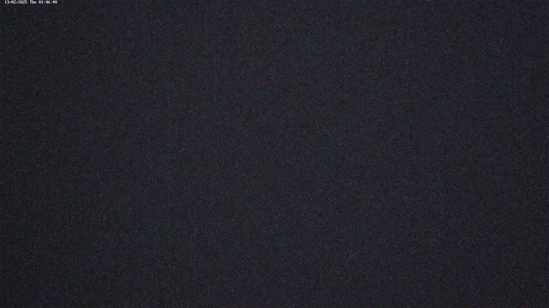 The image shows a dark, grainy, textured surface.