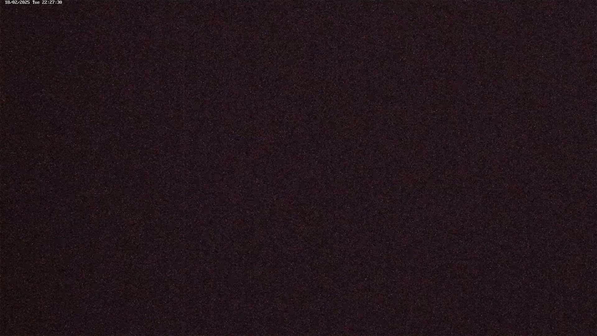 A dark, grainy image shows a night sky filled with numerous faint stars.