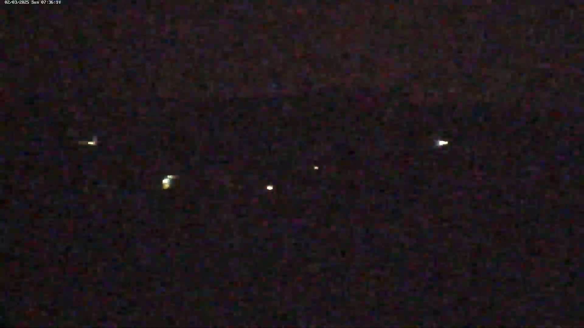 Several faint, distant lights are visible in the dark night sky.