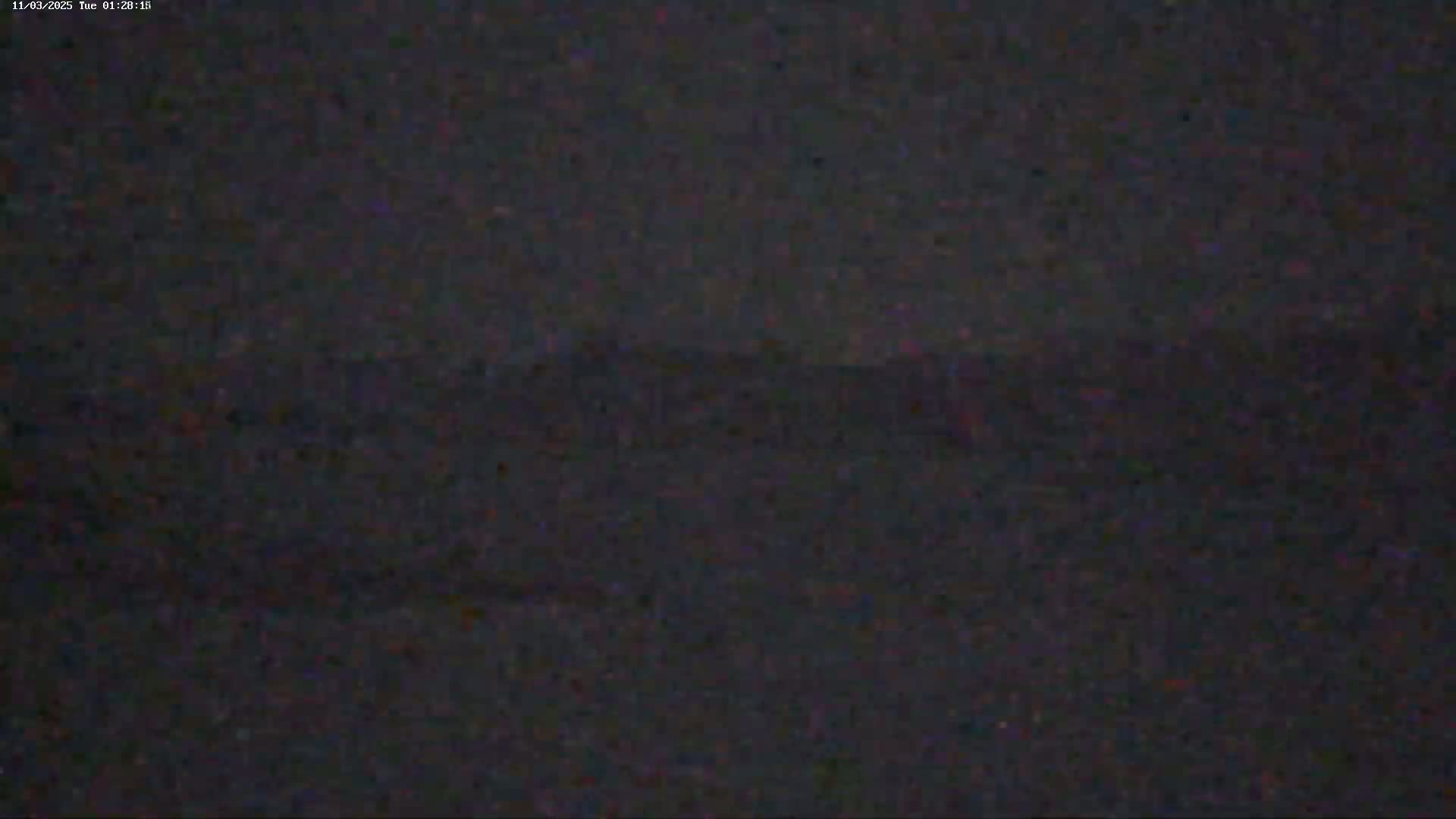 A dark, blurry image shows a low-lying horizon line under a nighttime sky.