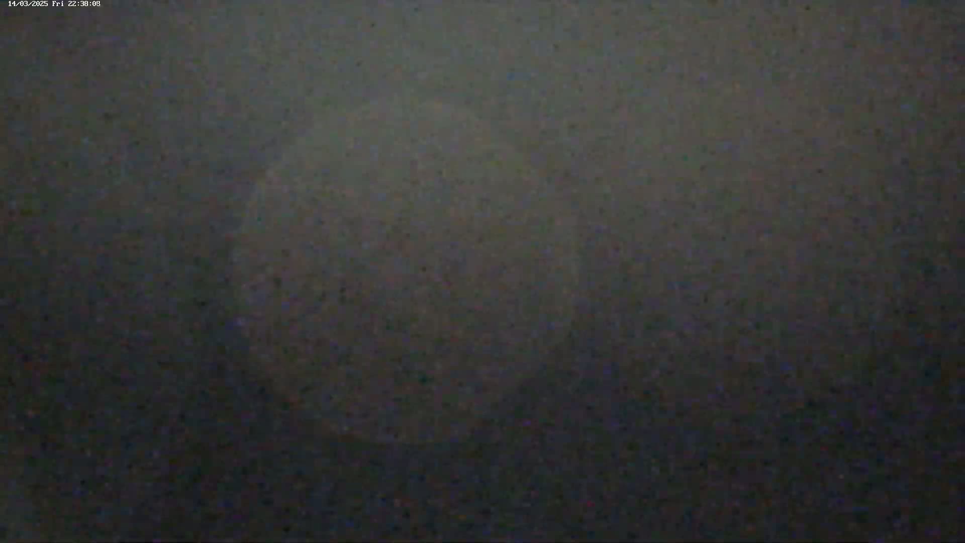 A blurry, out-of-focus image shows a large, hazy, light-colored circle against a dark, grainy background.