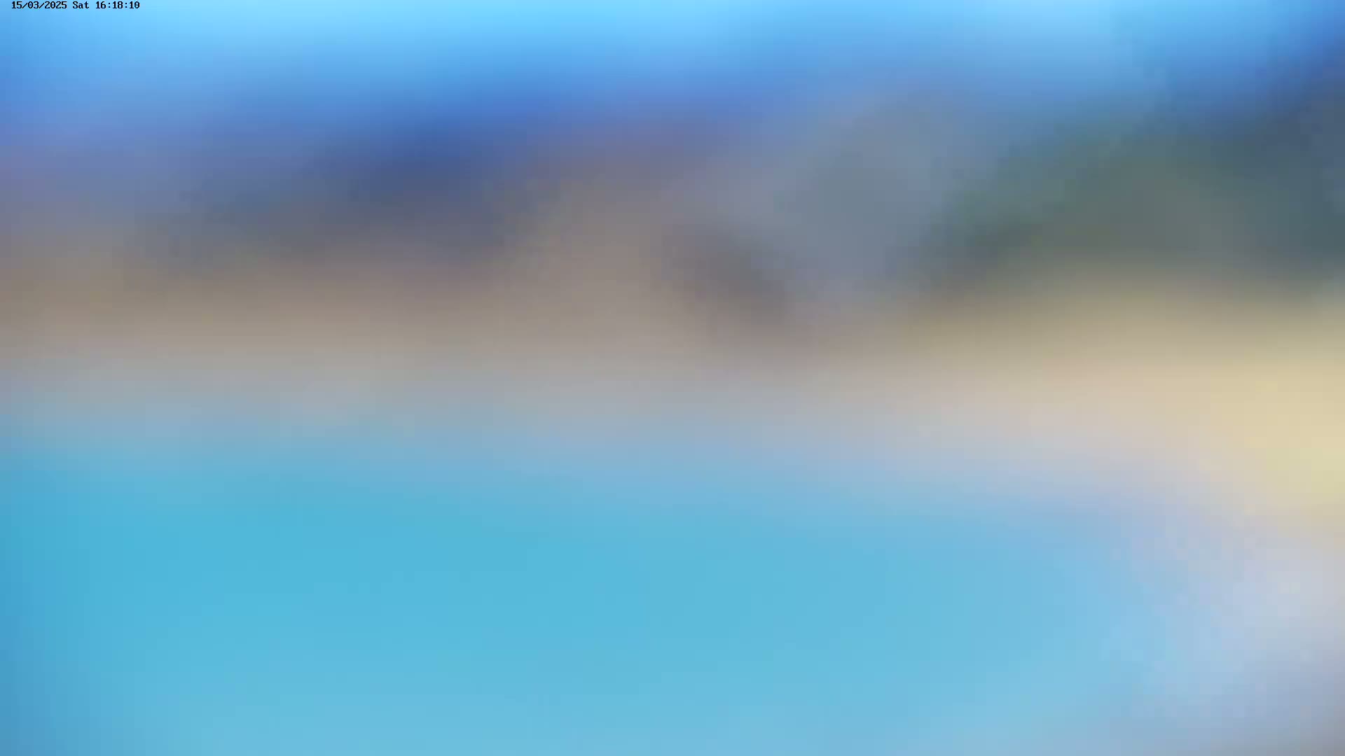 An out-of-focus image shows a blurry landscape of light blue water beneath a hazy sky that transitions from light blue to beige.