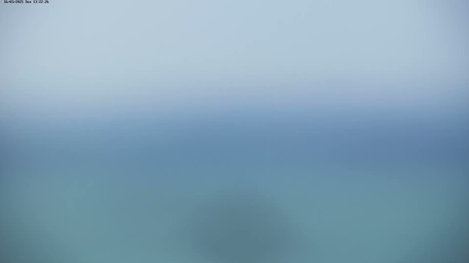A blurry image shows a hazy, light-blue sky grading into a darker blue body of water.