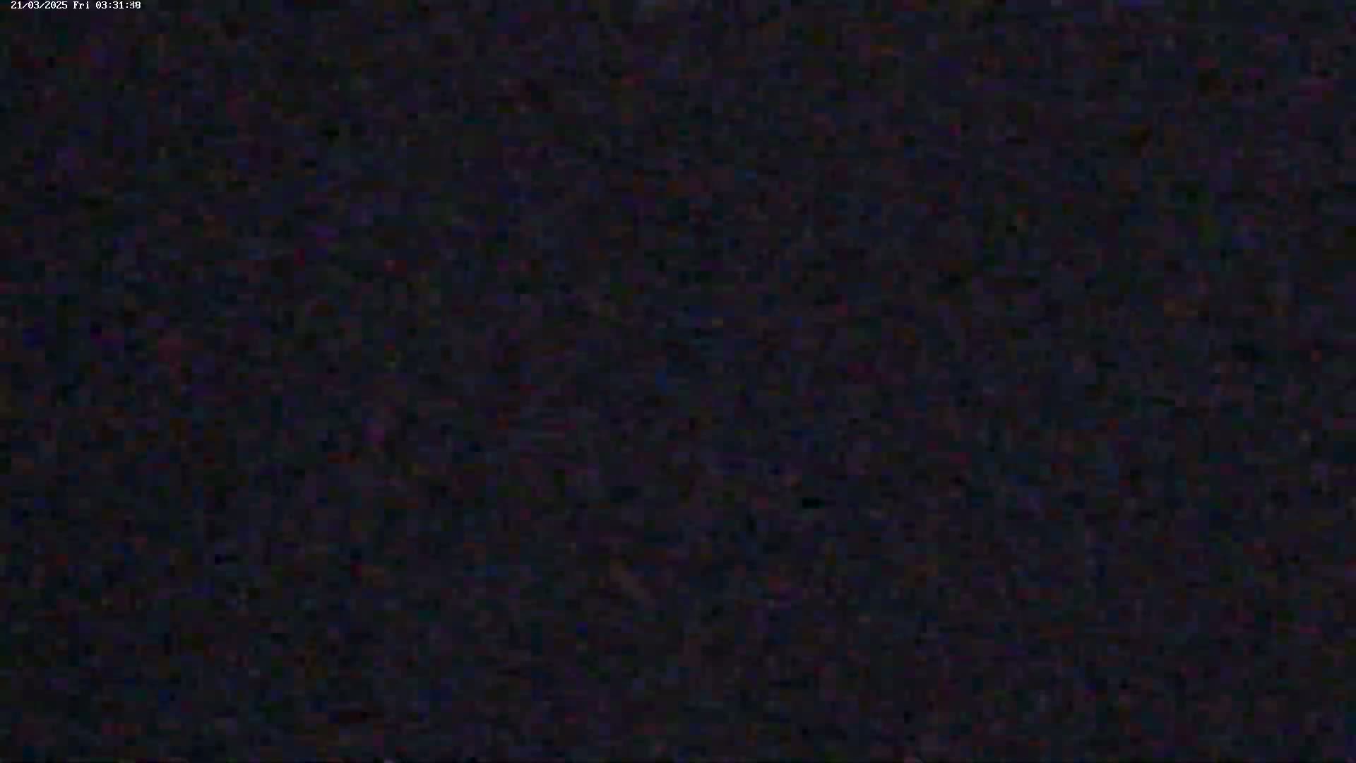The image is a dark, grainy, and blurry view of an indistinguishable scene.