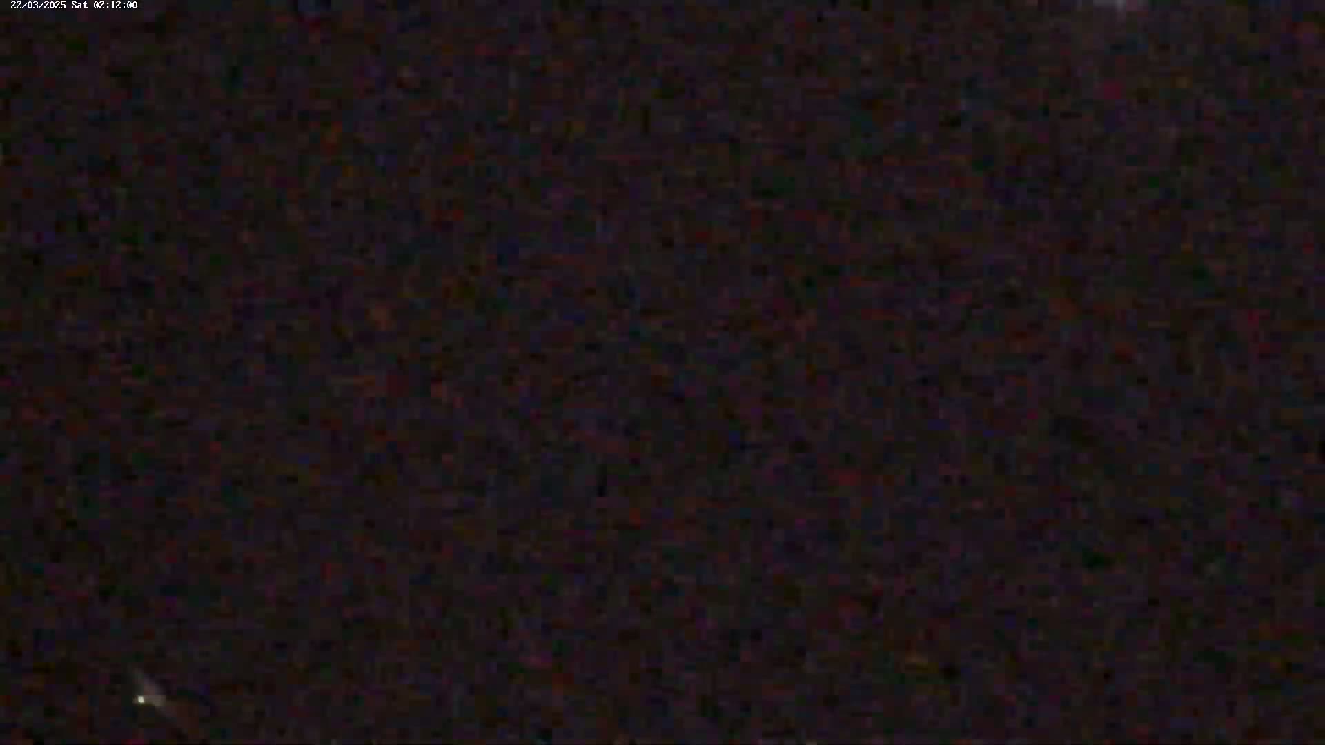 A grainy, dark image shows a mostly black night sky.