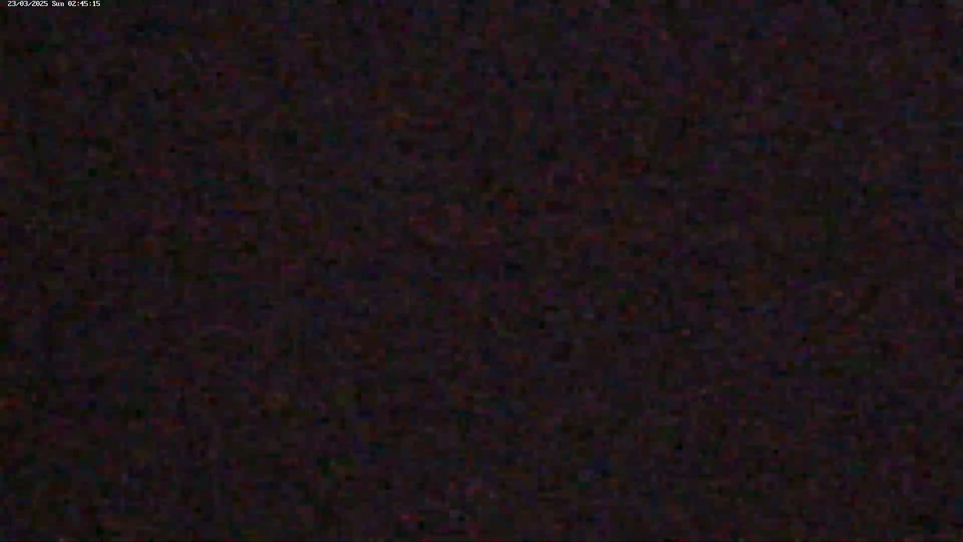 The image shows a dark, grainy, and indistinct view, possibly at night.