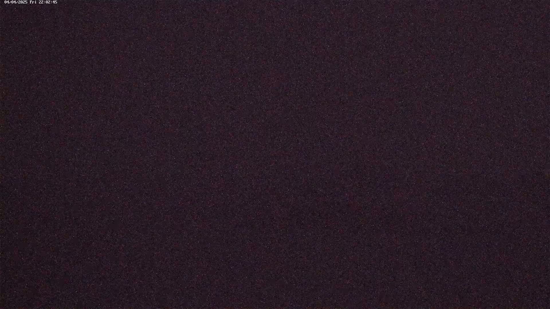A dark, grainy image shows a night sky filled with many faint stars.