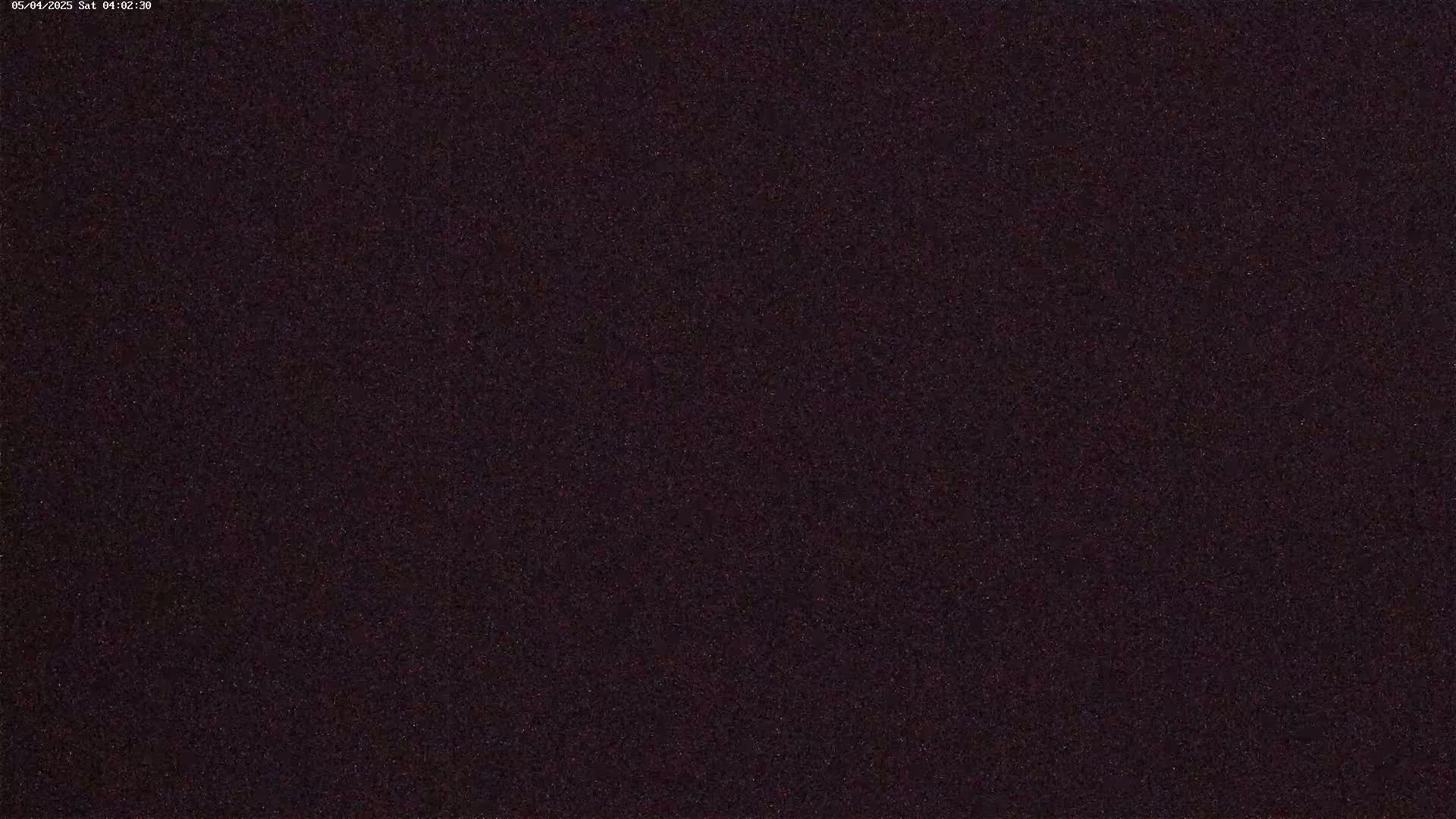 A dark, grainy image, possibly of a night sky.