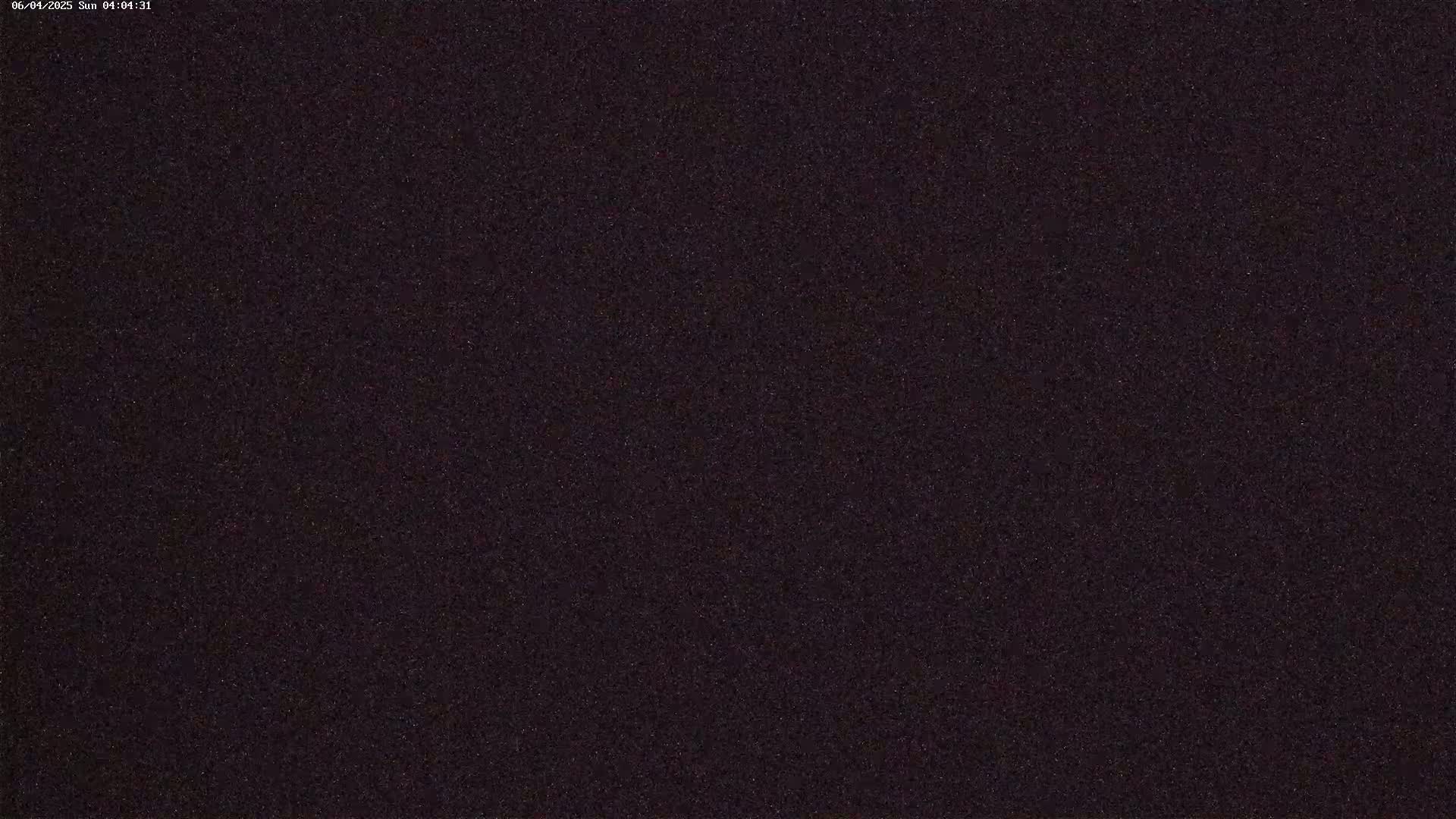 A dark, grainy image shows a night sky.