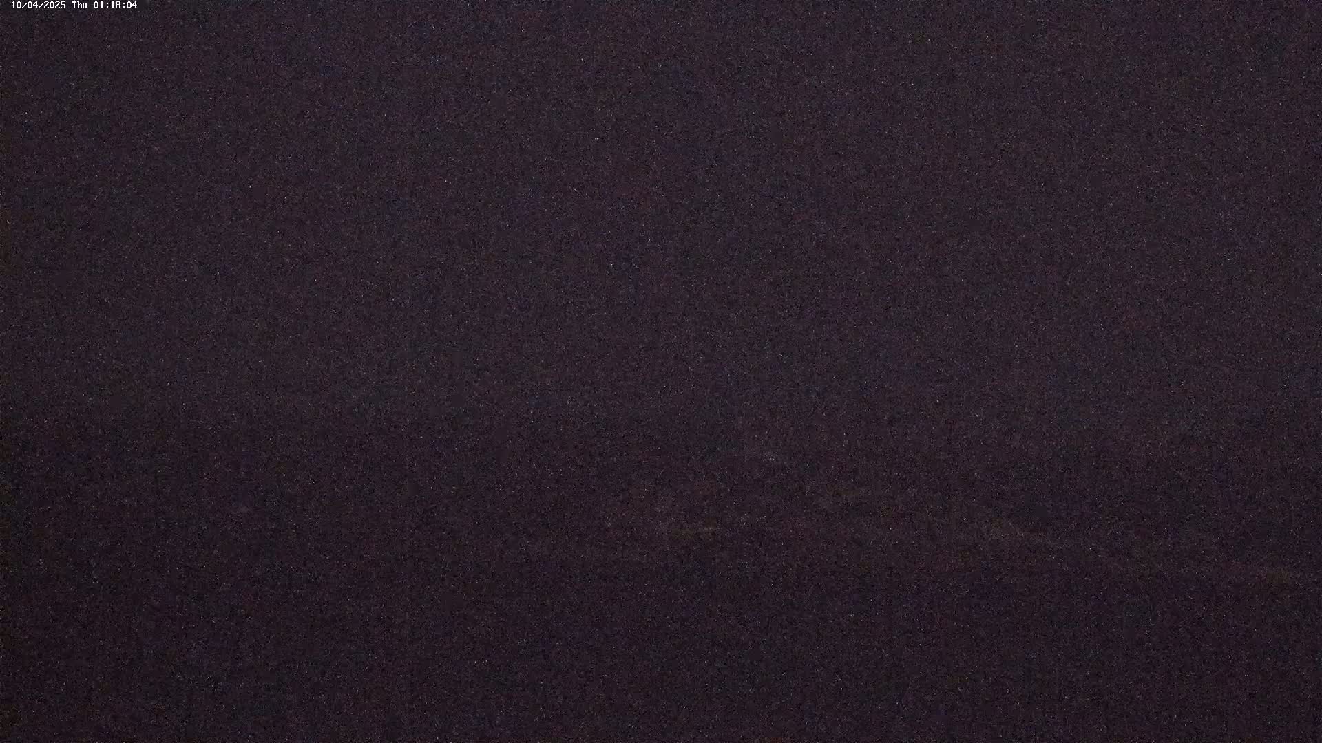 A dark, grainy image shows a mostly featureless night scene.