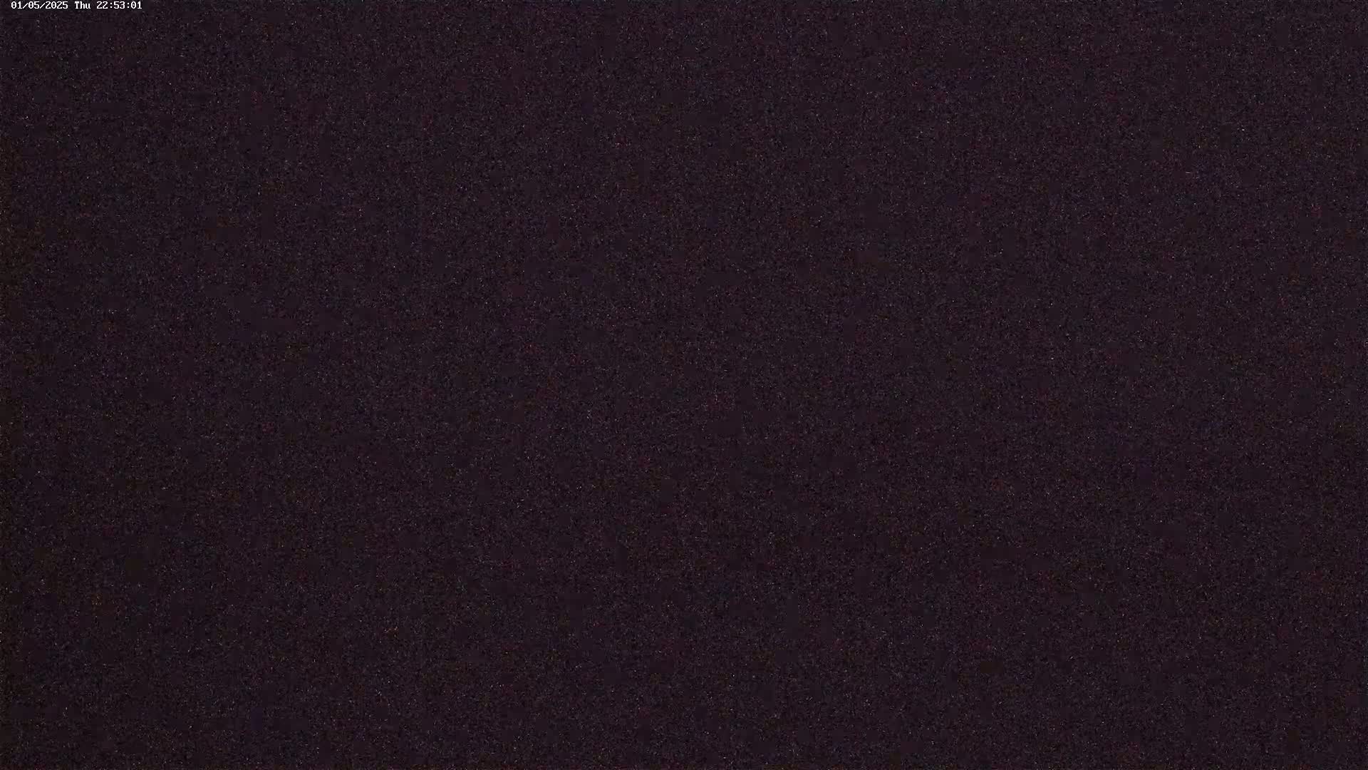 A dark, possibly nighttime, image shows a uniformly textured surface with subtle variations in shade.