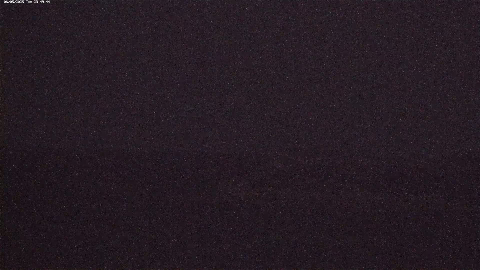 A dark, uniformly textured surface is shown under nighttime conditions.