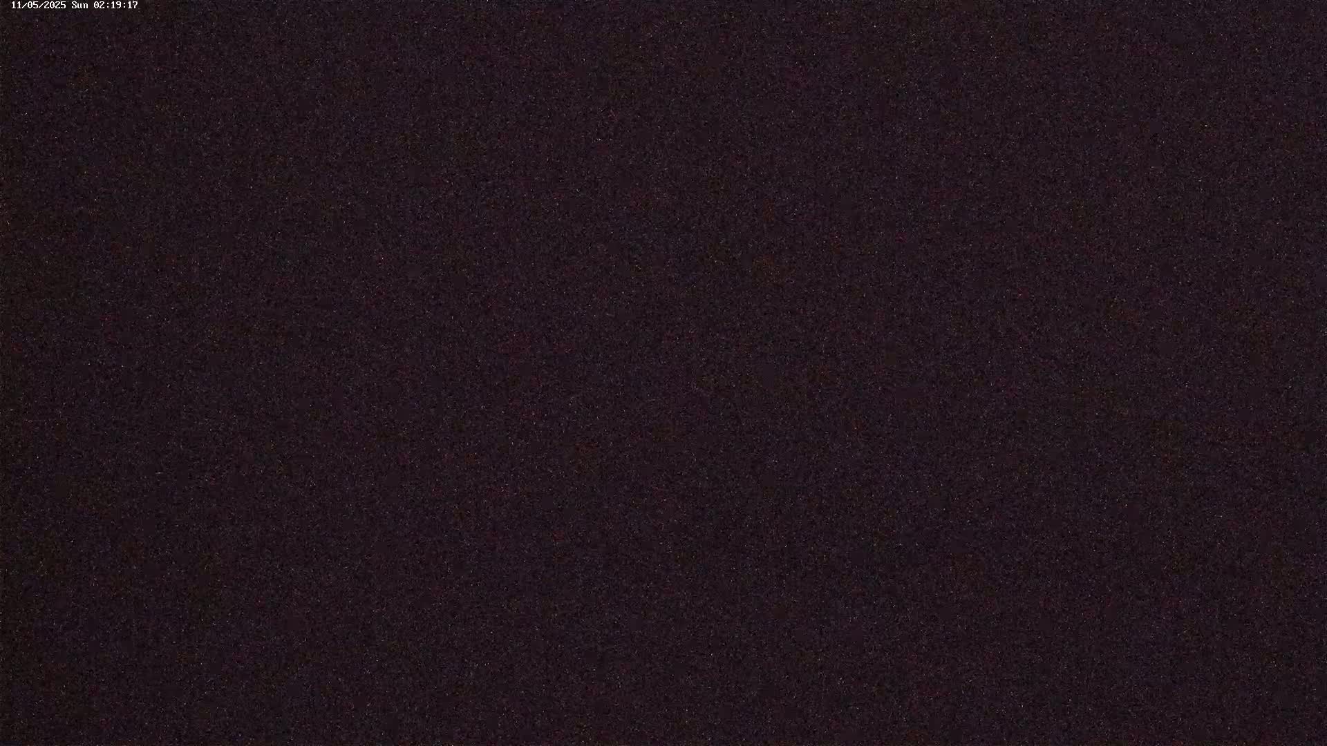 A dark, grainy image shows a night sky filled with many faint stars.