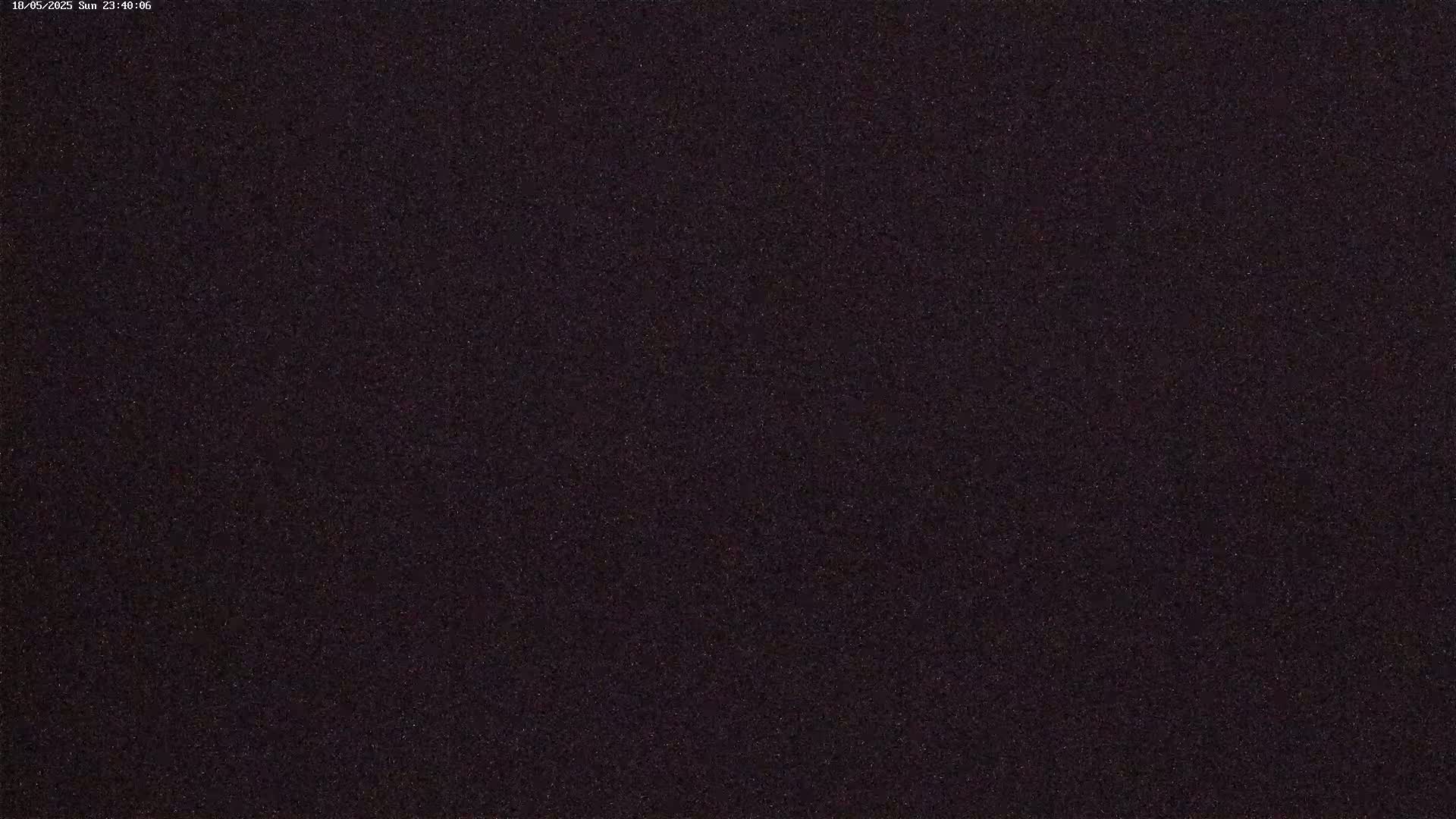 A dark, grainy image shows a night sky filled with many small, faint stars.