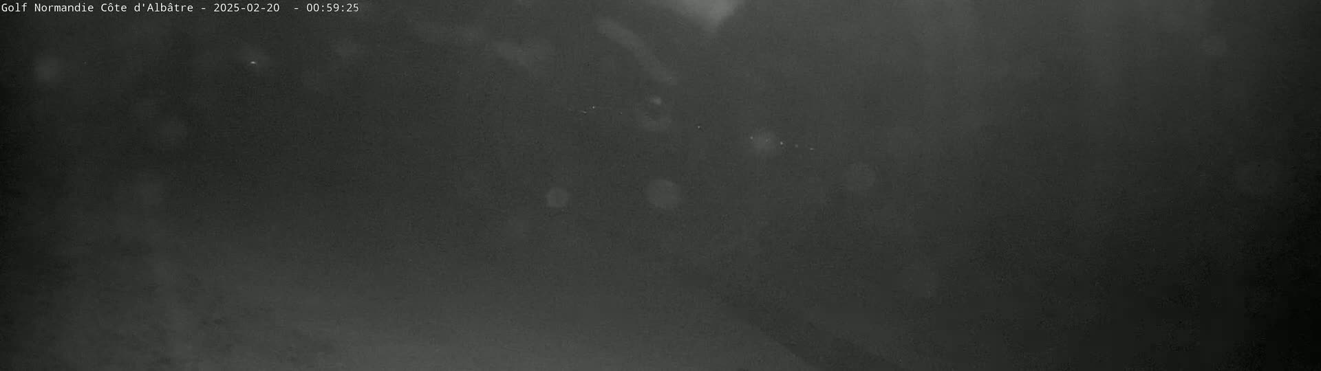 A dark, blurry image shows a night scene with very little visibility.
